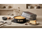 Cheesecake in springvorm met deksel, bakgerei en een stuk taart.