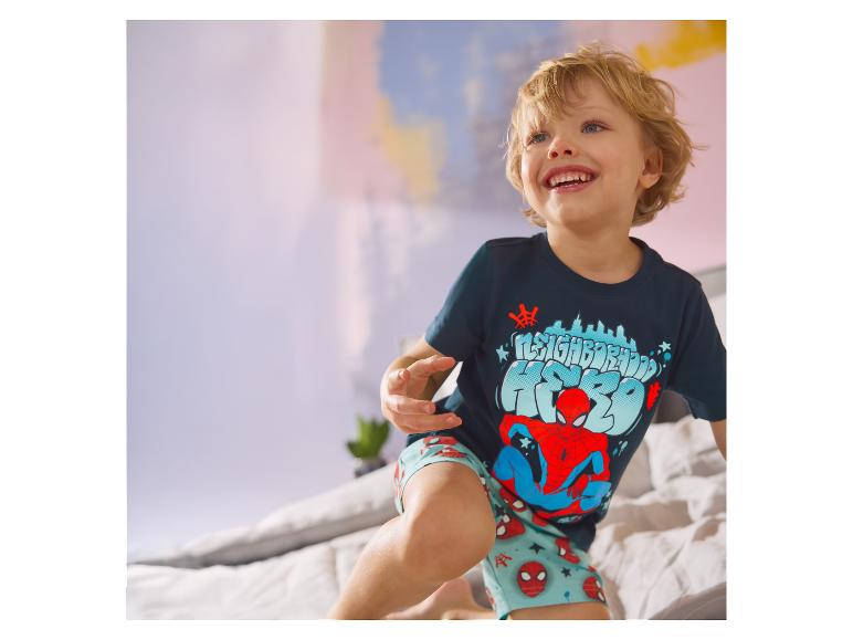 Kind in bed, dragend een LUPILU® kinderpyjama met Spider-Man-thema.
