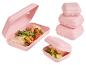 Roze lunchboxen met wraps en komkommers, en een stapel gesloten boxen.