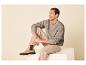 Man zit in een beige gebreide trui en broek, met beige enkellaarzen aan.