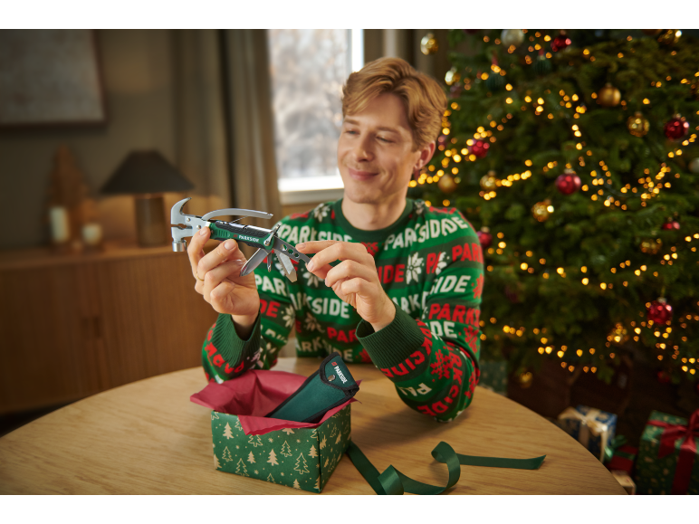 Man in kersttrui bekijkt een multifunctionele hamer.