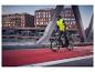 Man in CRIVIT thermo-hybride jas fietst over een stadsbrug.