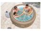 Vier vrienden proosten met drankjes in een opblaasbare jacuzzi op een terras.