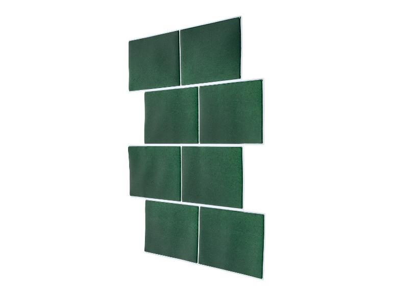 Groene zelfklevende wandtegels, verspringend geplaatst op een witte achtergrond.
