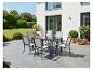 Tuinmeubelset met grijze tafel en zes stoelen op een terras.