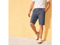 Man draagt blauwe shorts en witte sneakers
