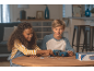 Twee kinderen zetten een blauwe 3D-autopuzzel in elkaar aan een houten tafel.