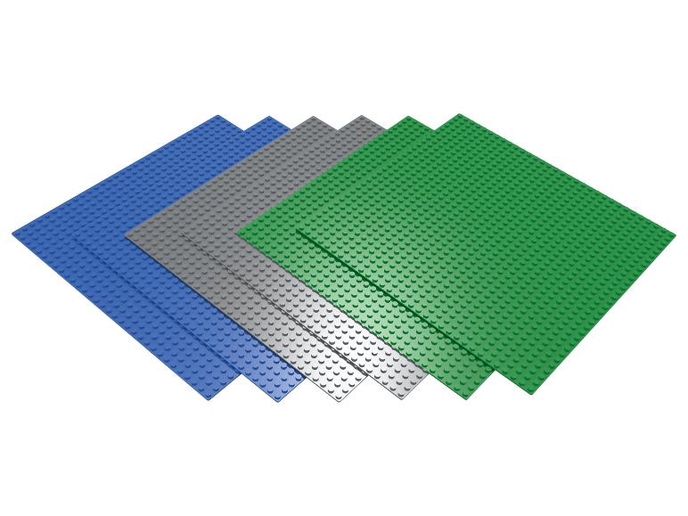 Vier Lego bouwplaten, twee blauw, één grijs en één groen.