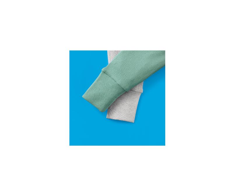 Twee geribbelde stoffen mouwen, één lichtgroen en één lichtgrijs, op een blauwe achtergrond.