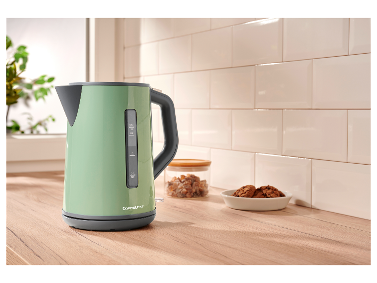 Een mintgroene SilverCrest waterkoker op een houten aanrecht.