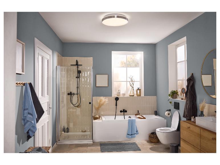 Moderne badkamer met douche, bad, toilet en houten wastafelmeubel.