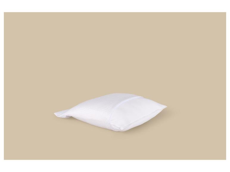 Wit kussen met honingraattextuur op een beige achtergrond.
