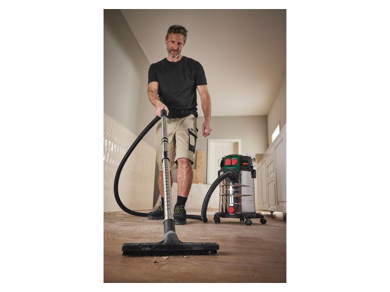Een man gebruikt een Parkside stofzuiger om de vloer schoon te maken.