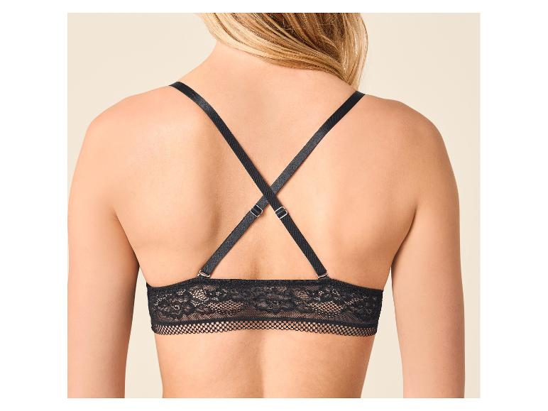 Vrouw in zwarte kanten bralette met gekruiste bandjes op de rug.
