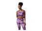 Vrouw in sportbeha en legging met paars abstract patroon.