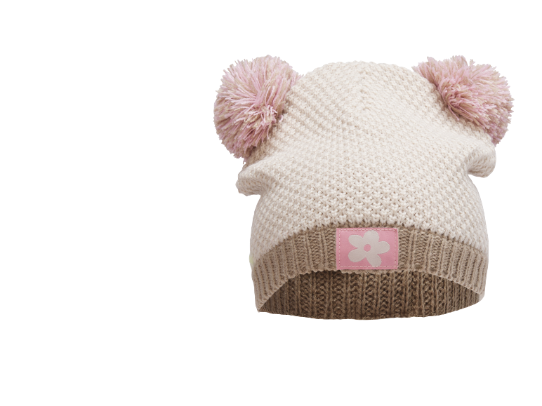 Gebreide kinderpet met twee roze pompons en een roze bloemenembleem.