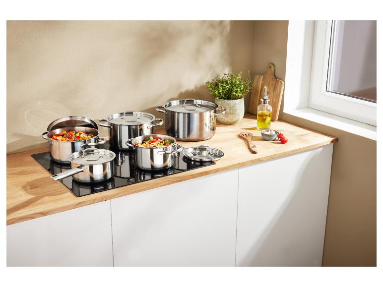 Set roestvrijstalen potten en pannen op een inductiekookplaat in een moderne keuken.