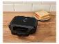 Zwart tosti-apparaat met indicatielampjes en twee sneetjes brood op een bord.
