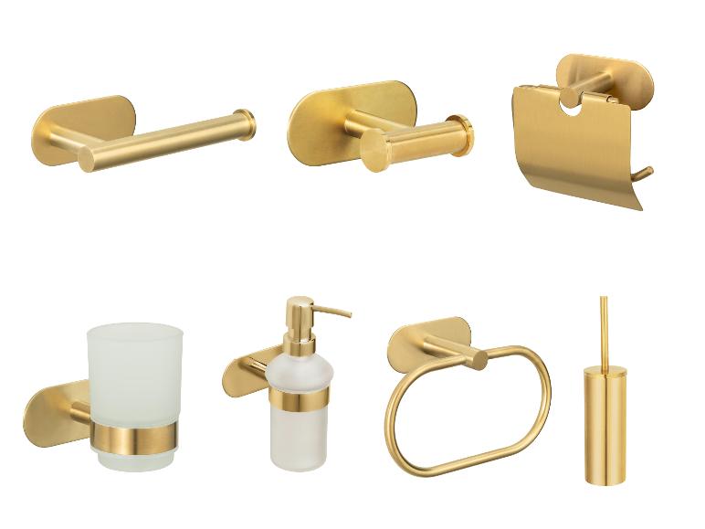 Gouden badkameraccessoires: toiletpapierhouder, zeepdispenser, tandenborstelhouder.
