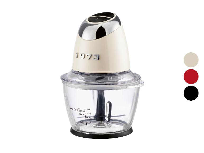 Een crèmekleurige retro-voedselhakselaar uit 1973 met een transparante kom.