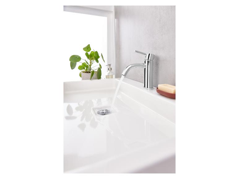 Een wastafel met een chromen kraan waar water uit stroomt.