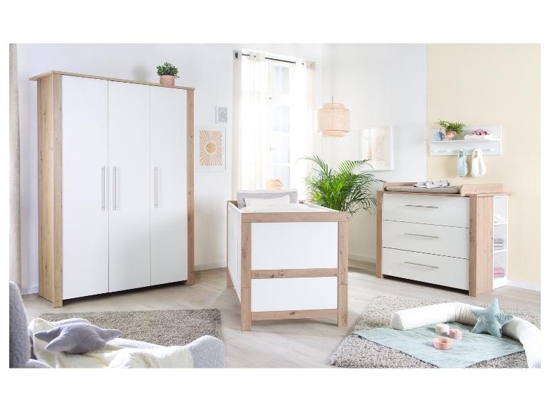 Moderne babykamer met kledingkast, ledikant en commode in hout en wit.
