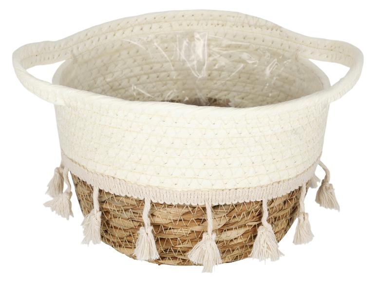 Gevlochten mand met handvatten, beige-bruin, met kwastjes en beschermfolie binnenin.