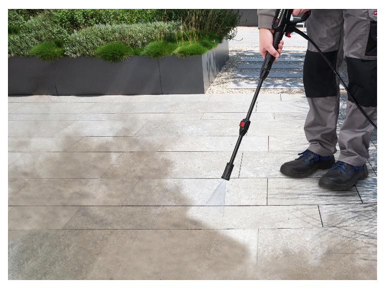 Iemand maakt een terras schoon met een Parkside hogedrukreiniger.