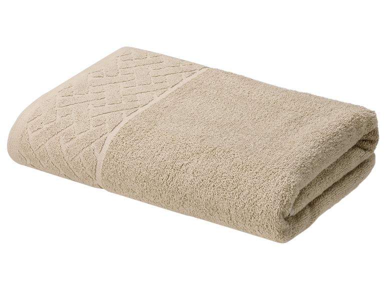 Gevouwen beige handdoek met een patroonrand