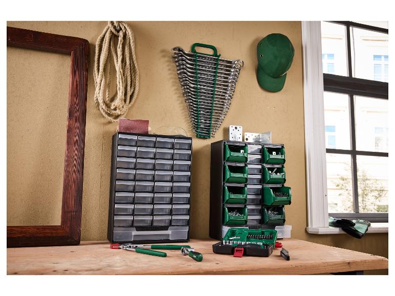 Gereedschapsopslag met laden en bakken, moersleutels en gereedschap op een houten tafel.