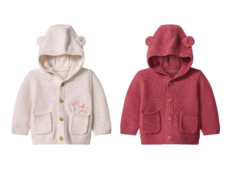 Twee gebreide babyvestjes, één crème met bloemenborduurwerk en één rood, beide met een capuchon met oren.