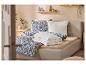 Gezellige slaapkamer met gestoffeerd bed, blauw bloemenbeddengoed en houten planken.