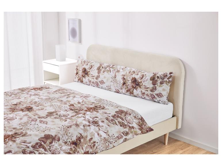 Slaapkamerinrichting met bruin bloemenbeddengoed en een beige bedframe.