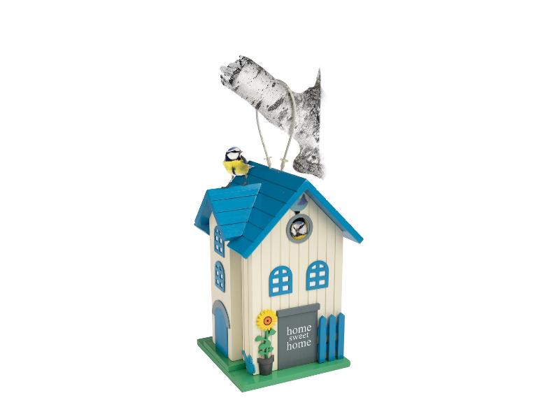 Vogelhuisje met blauw dak, een zonnebloem en twee vogels, één op het dak en één erin.
