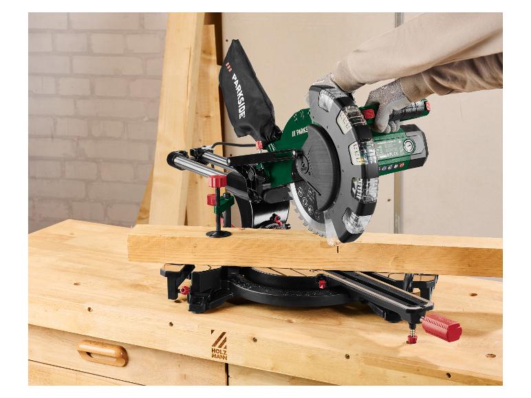 Een persoon zaagt hout met een afkortzaag op een werkbank.