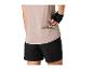 Vrouw in beige sportshirt en zwarte shorts haalt een reep uit haar zak.