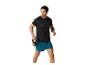 Een man in een zwart shirt en teal shorts houdt een kettlebell vast.