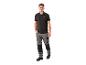 Man in zwart poloshirt en grijze werkbroek.