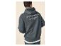 Man in een donkergrijze hoodie met de tekst 'THE DENIM CLUB Crafted Garments ORIGINAL DENIMS' op de rug.