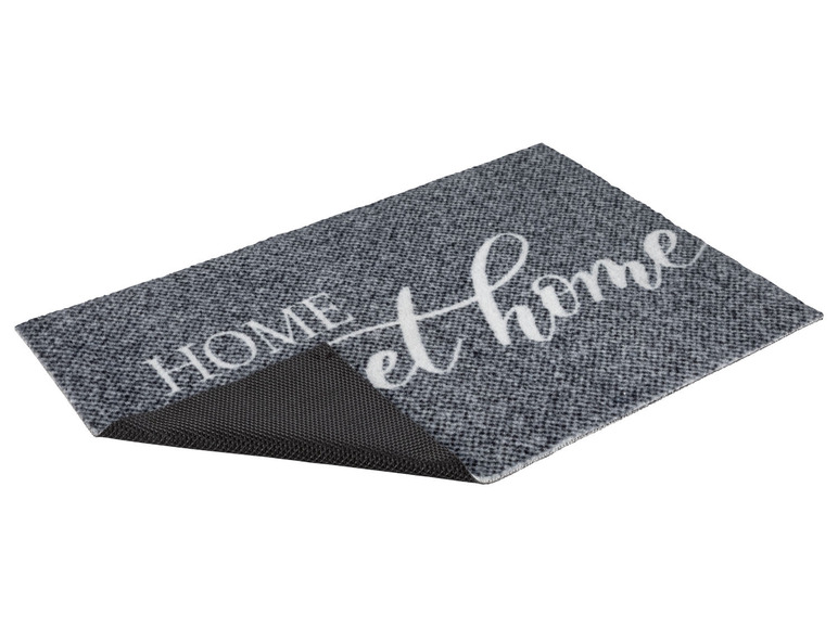 Een grijze deurmat met de tekst 'Home' erop.