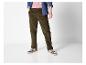 Man in bruine corduroy broek, roze T-shirt en spijkeroverhemd.