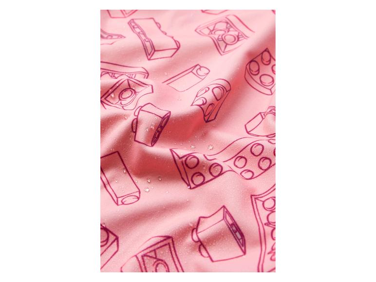 Roze stof met een patroon van camera's en speelgoedblokken, met waterdruppels.