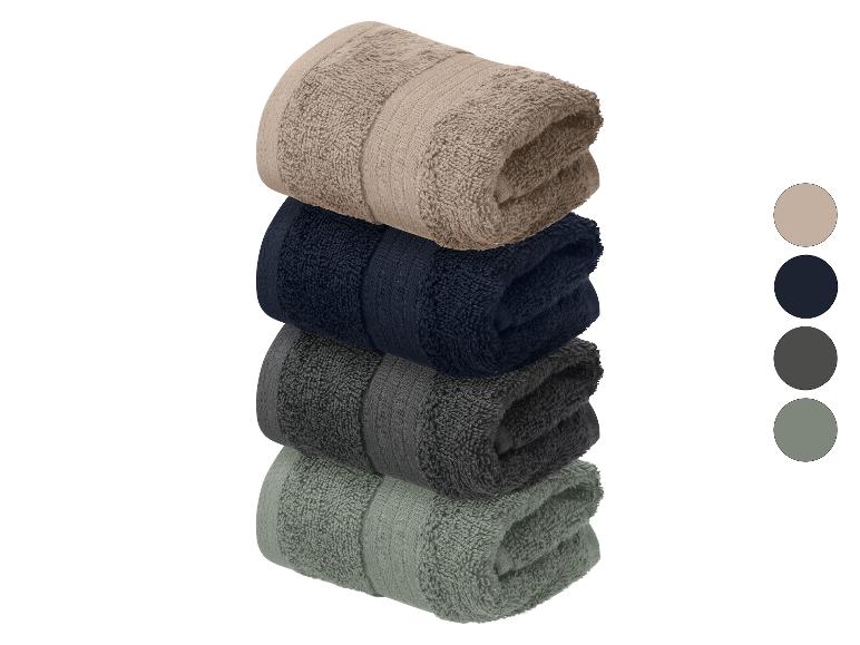 Set van vier gevouwen handdoeken in neutrale kleuren: beige, marineblauw, donkergrijs en grijsgroen.