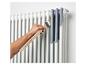 Een witte radiator grijs verven met een kwast