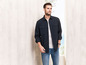 Man in een donkerblauwe overhemd en blauwe jeans.