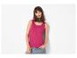 Vrouw in fuchsia tanktop en blauwe jeans, poserend met haar hand in haar zak.