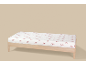 Wit hoeslaken met rood strikjespatroon op een houten bed.