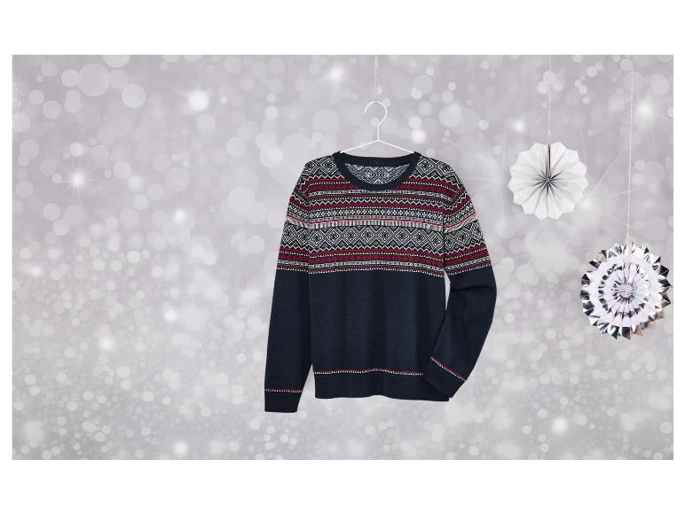 Een donkerblauwe trui met een Scandinavisch patroon hangt tegen een zilveren achtergrond.
