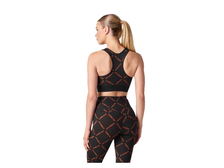 Vrouw in een zwarte sportbeha en legging met oranje patroon, van achteren gezien.