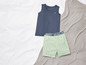Een donkerblauwe tanktop en lichtgroene shorts op een wit bed